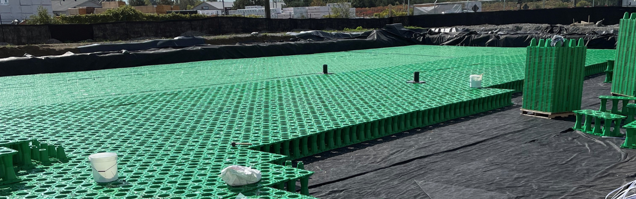 Módulos geocelulares verdes de detención de aguas pluviales ensamblados en una excavación impermeabilizada